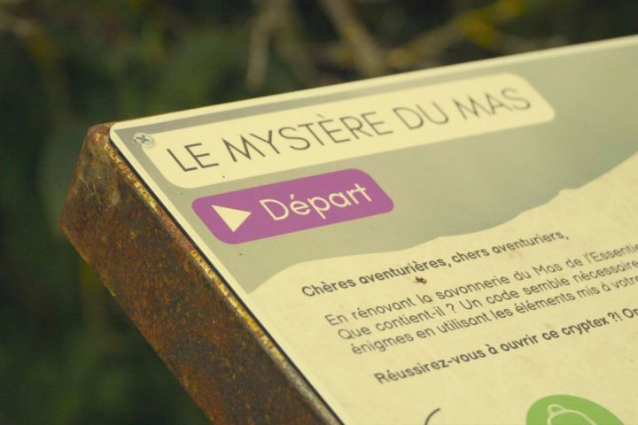 Close-up of a sign titled 'Le Mystère du Mas' with a purple 'Départ' button.