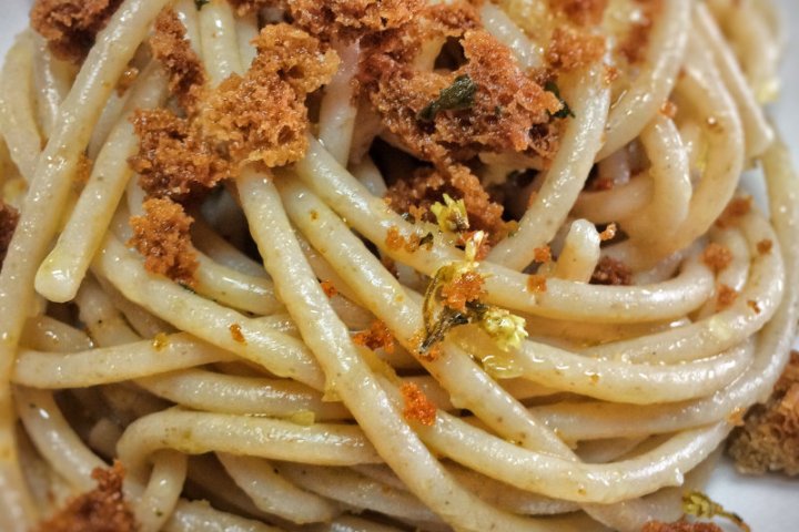 Close-up of pasta with breadcrumbs on a plate.
