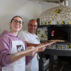 Wood-fired oven baking Margherita pizza in Italy