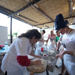 Guests shaping pizza dough during cooking class