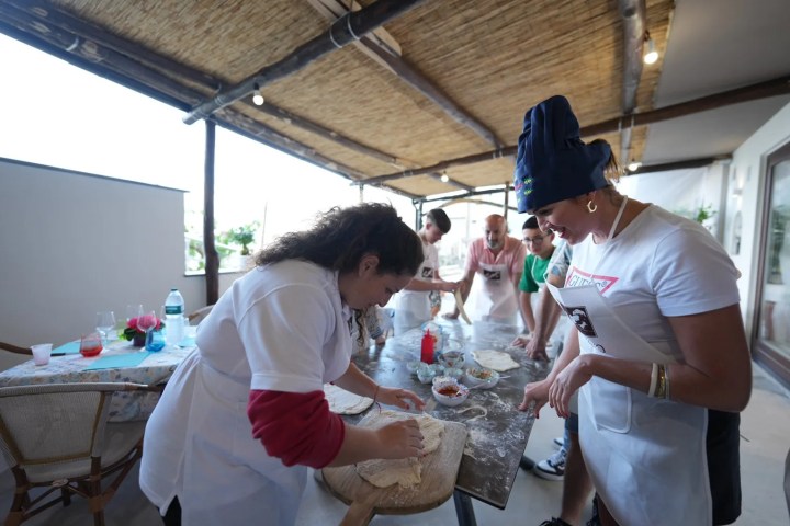 Guests shaping pizza dough during cooking class