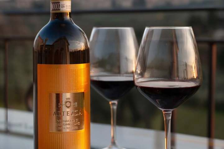 Wine bottle and two glasses on a table with a city skyline backdrop.