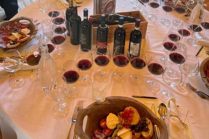 Table with wine bottles, filled glasses, and charcuterie platters.