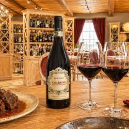 Elegant dining room with wine bottle, glasses, and food on table.