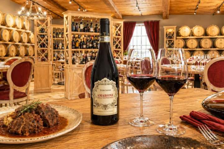 Elegant dining room with wine bottle, glasses, and food on table.