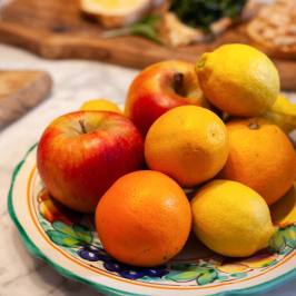 Bowl of apples, oranges and lemons on a Tuscan ceramic plate