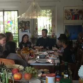 Guests at a long tasting lunch in a Tuscan farmhouse dining room
