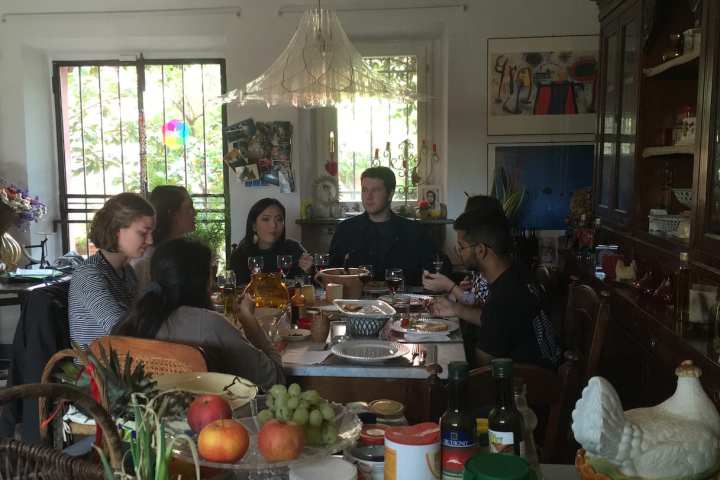 Guests at a long tasting lunch in a Tuscan farmhouse dining room