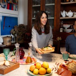 Guests at a farmhouse table with bread, oranges and olive oil in Chianti